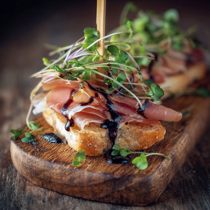 Crostini prosciutto en éventail, glaçage balsamique & micropousses